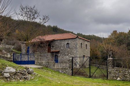 在一个多云的冬日,一个多山的乡村里的旧石头乡间房子(希腊佩洛蓬尼斯