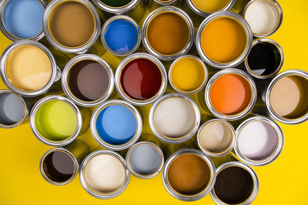 红色背景上满桶彩虹色油漆照片