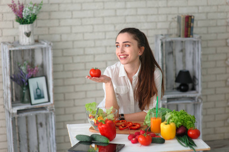 年轻的女人做饭。 健康食品蔬菜沙拉。 饮食。 健康的生活方式。 在家做饭。 准备食物