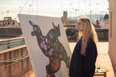 年轻的妇女绘画艺术家画在屋顶