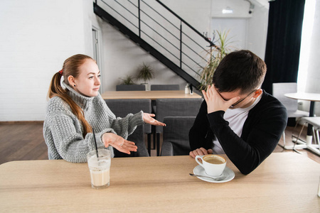 糟糕的关系概念。男人和女人在分歧。年轻夫妇坐在咖啡馆里吵架, 得罪了妻子和不幸的丈夫