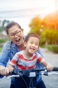 亚洲儿童骑自行车肖像，母亲笑脸幸福情感