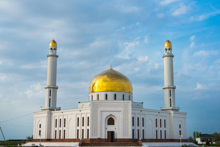 穆斯林清真寺的中央入口门. 日落背景上的清真寺. 夜间景观尖塔.