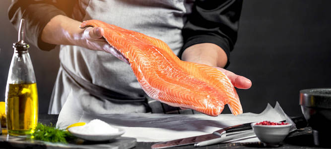 他用刀子切三文鱼片照片