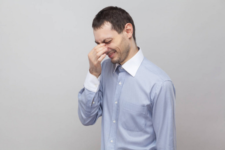 满意侧站在灰色背景下哭泣的悲伤孤独商人的侧景肖像照片