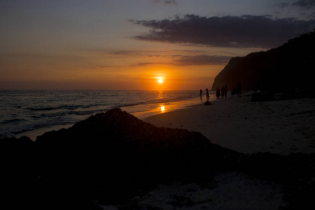 美丽的海滩景色，人的轮廓和夕阳