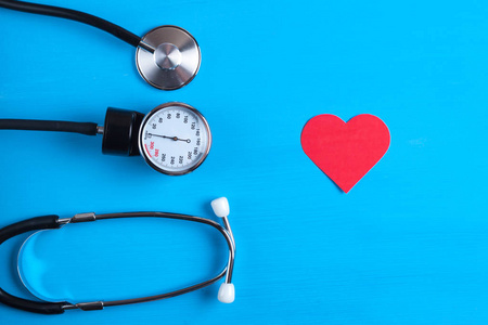医学概念。 音调计听诊器和心脏在蓝色背景上。 血压的测量。
