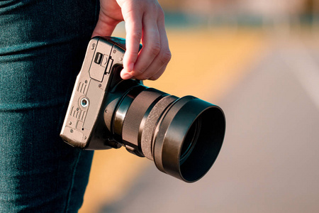 业余专业摄影. 一个年轻的女人拿着一个带镜头的照相机照片