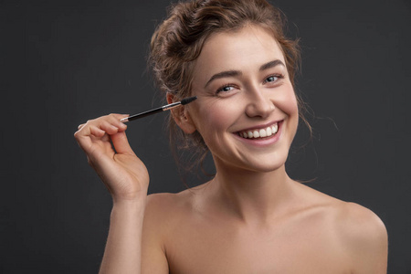 清洁新鲜自然无瑕的皮肤. 她脸上温柔的微笑. 接近中立的背景照片