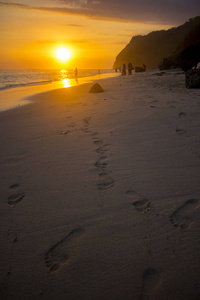 美丽的海滩景色，人的轮廓和夕阳