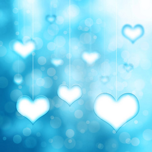青色蓝色的心挂在薄薄的白色绳子上模糊的背景上。 概念情人节复制空间插图。