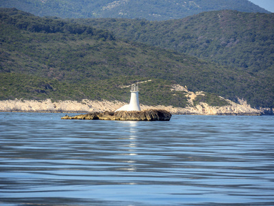 美丽的克罗地亚绿色岛屿，前面是岩石上的小灯塔。