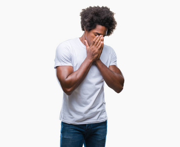 美国黑人男子在孤立的背景上,悲伤的表情覆盖着脸,用手哭泣.