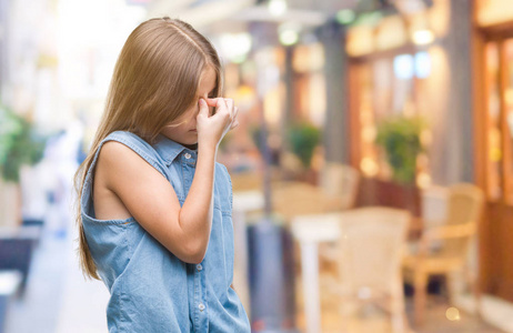 年轻漂亮的女孩在孤立的背景下疲惫地揉着鼻子和眼睛,感到疲劳和头痛