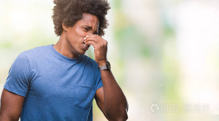 美国黑人男子在孤立的背景上闻到一些臭味和令人恶心的难以忍受的气味