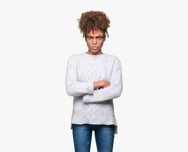 美丽的年轻非洲裔美国妇女穿着冬季毛衣，在孤立的背景怀疑和紧张的不赞成的表情在脸上交叉的手臂。 消极的人。