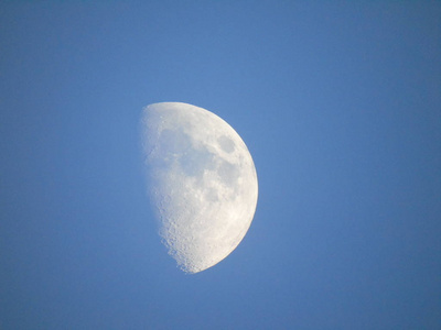 一张令人惊叹的照片，拍摄于热那瓦市上空的满月，背景是晴朗的天空和一些星星