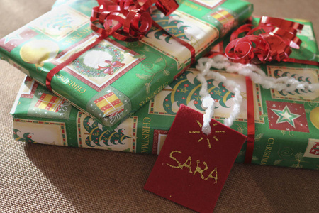 关闭两个礼品包与萨拉名牌绿卡和红弓与棕色背景