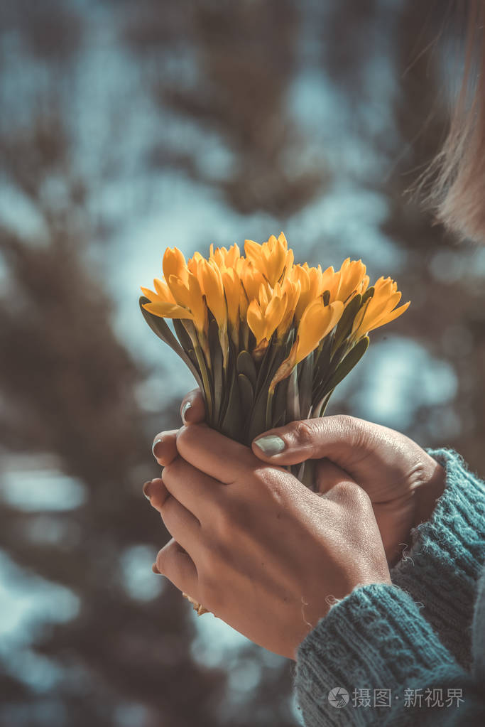 女人拿着一束黄花