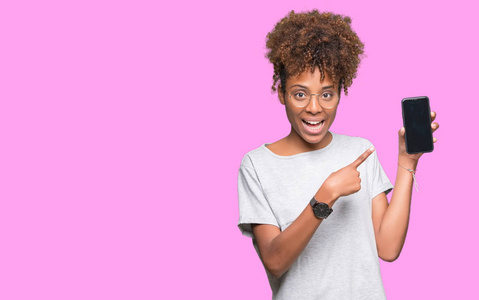 年轻的非洲裔美国妇女显示智能手机屏幕在孤立的背景下，非常高兴地用手和手指指点。