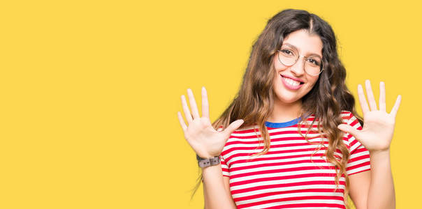 年轻漂亮的女人戴着眼镜，用十号手指举着，微笑着自信快乐。