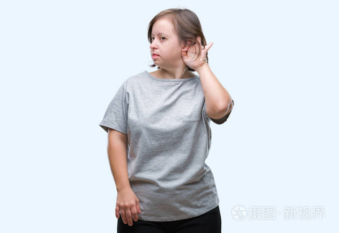 年轻的成年妇女患有唐氏综合症在孤立的背景下微笑用手捂住耳朵听谣言