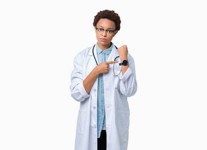 年轻的非裔美国医生女士穿着医用外套，背景偏僻，匆忙地指着看时间，不耐烦，心烦意乱，为最后期限的延迟而生气