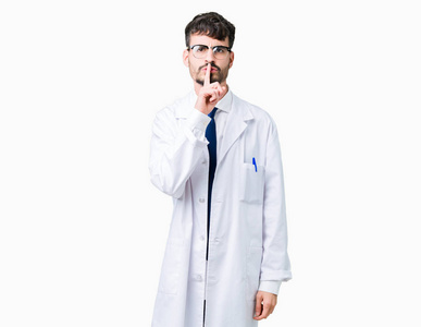 年轻的职业科学家，穿着白色外套，在孤立的背景上要求安静，手指在嘴唇上。 沉默和秘密的概念。