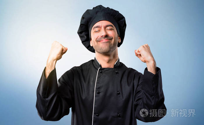 身穿黑色制服的厨师在蓝色背景下庆祝胜利