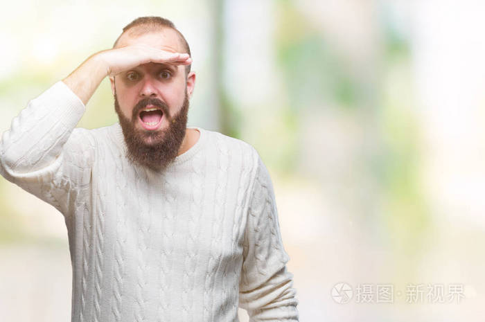 穿着冬天的毛衣,在孤立的背景下,非常快乐,微笑着,用手捂住头看着远方