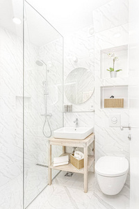 明亮的新浴室内部与玻璃步行淋浴与大理石瓷砖环绕