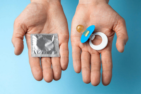 在男子手中的婴儿奶嘴和避孕套在包里.