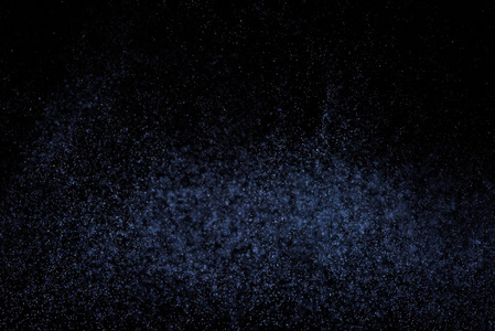 黑色背景上抽象的蓝色水溅。 白色粒子的冻结运动。 雨雪覆盖纹理。