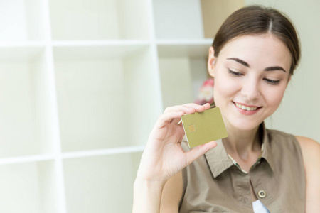 女性手拿信用卡进行网上购物，快乐享受轻松无现金支付与文字空间。