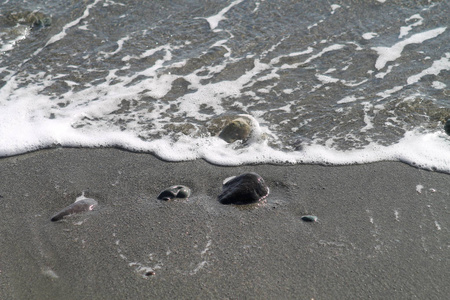 塞浦路斯利马索尔沙滩上的泡沫海浪和一些卵石