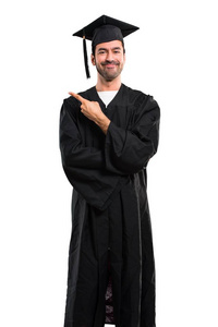 在他的毕业典礼上，男人用手指指着一边，一边展示一个产品或一个想法，一边期待微笑