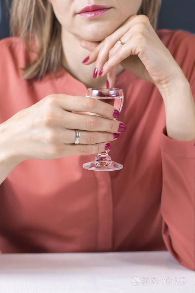 那个女人手里拿着一杯伏特加照片-正版商用图片16oler-摄图新视界