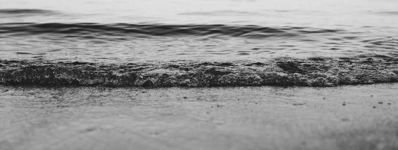 小沙浪在沙滩上溅起小浪照片