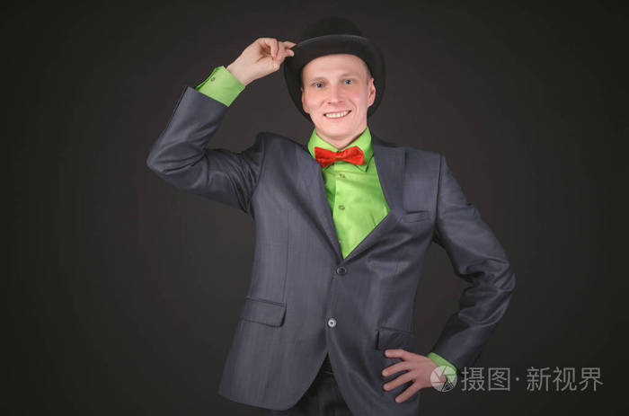 男人正在黑色背景上从头上摘下他的保龄球帽子绅士是问候