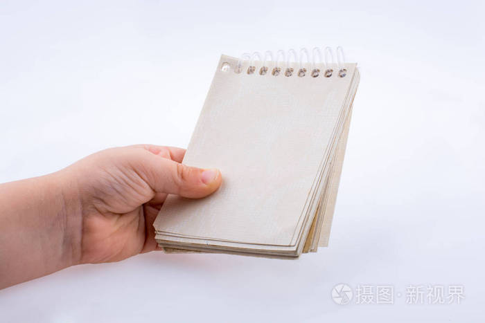 手拿棕色笔记本在白色背景上照片-正版商用图片16orcj-摄图新视界
