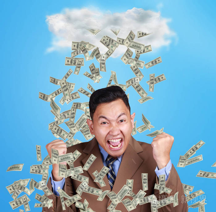 幸福成功的年轻亚洲亿万富翁的肖像在金钱的雨下快乐地微笑财富投资