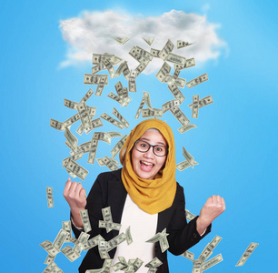 下钱雨幸福成功的年轻亚洲亿万富翁女人在金钱的雨下快乐地微笑的肖像