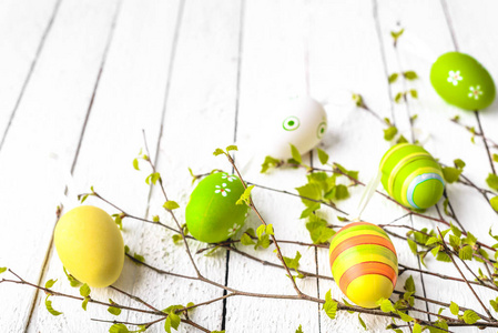 春季复活节彩蛋背景。 在白色的木桌上画鸡蛋。