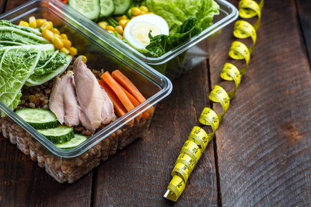 健康膳食在塑料容器和测量磁带。 午餐盒。 营养和健康食品理念。 饮食和减肥的概念。 吃得对，监测你的健康。