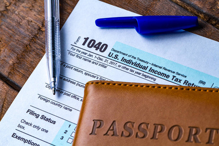 填写美国税单。 税单1040纳税人护照和木桌上的钢笔。 财务概念税收概念。 个人所得税申报表。 缴税时间