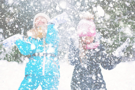 两个孩子在下雪下玩耍和跳舞。