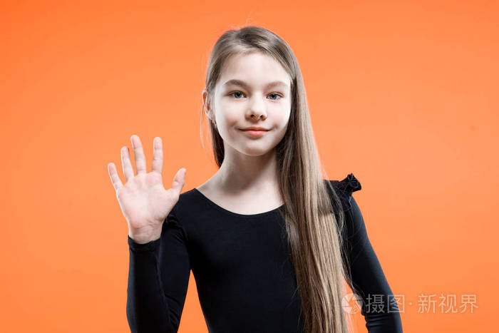你好手势微笑的女孩挥手问候橙色背景