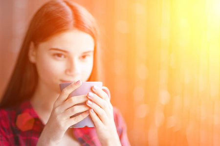 一个十几岁的女孩在周末早上喝杯茶放松。