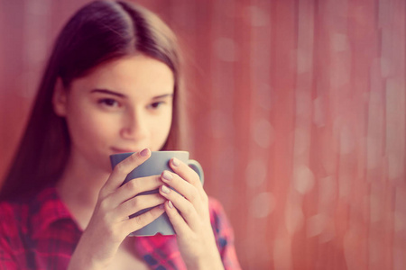 一个女孩正在喝茶，梦中带着微笑。