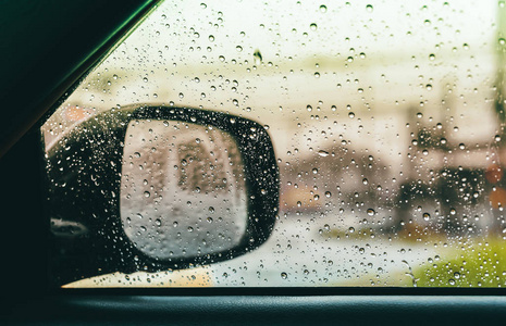 模糊的雨滴在汽车玻璃背景水滴在车窗司机一侧。